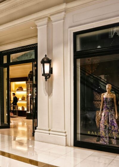 Vitrine de boutique de luxe avec mannequin en robe sophistiquée.